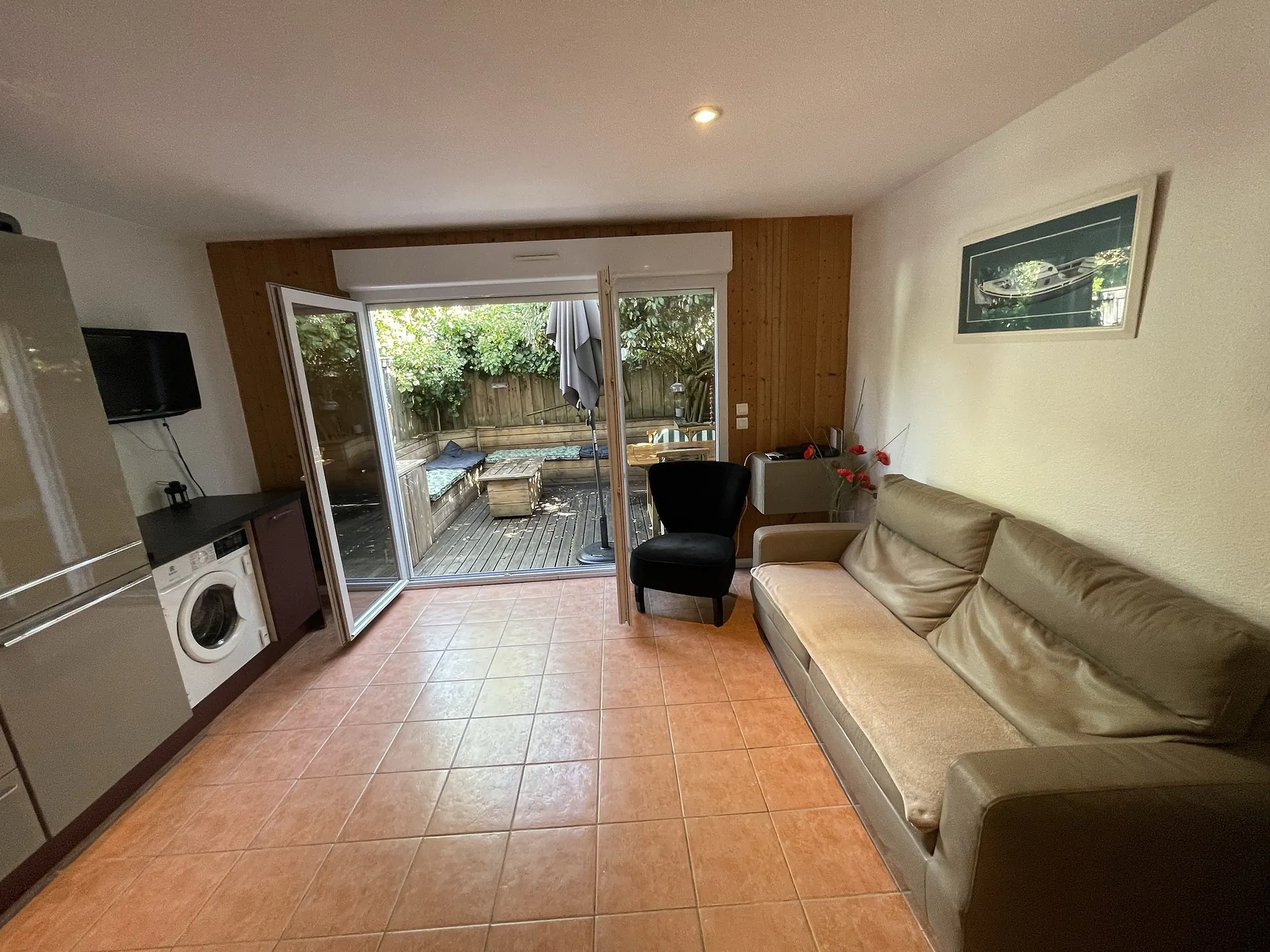 The living room opening onto the terrace through a wide glass door, with its leather sofa